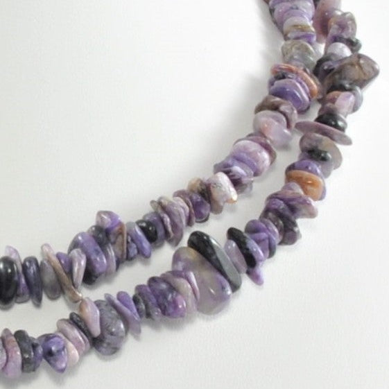 Purple beaded necklace on a white background