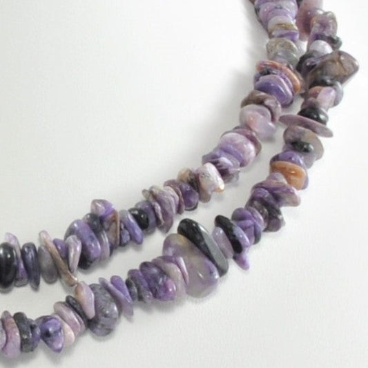 Purple beaded necklace on a white background