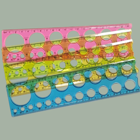 Four translucent plastic drafting rulers in pink, orange, green, and blue, stacked diagonally on a light off-white background.