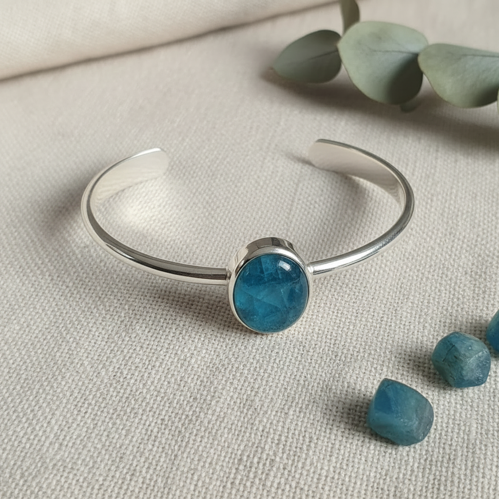 Silver bracelet with a blue gemstone on a light fabric background