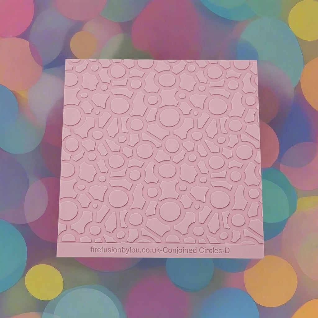 Conjoined circles. A continuous pattern debossed texture mat in pink material, size 100mm x 100mm. 