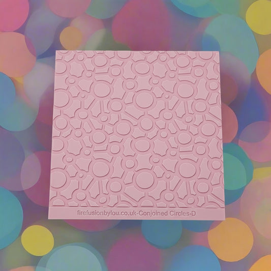 Conjoined circles. A continuous pattern debossed texture mat in pink material, size 100mm x 100mm. 