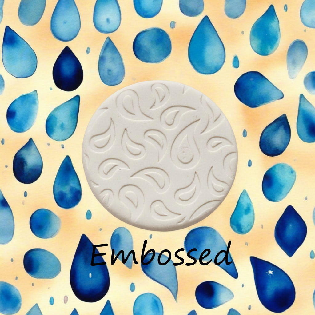 A raindrop pattern debossed in clay using a patterned embossed texture mat.