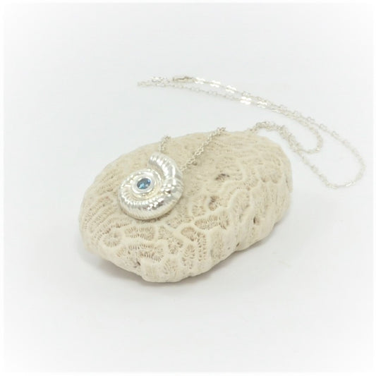 This substantial 999 fine silver fossil pendant features a dual link 925 silver chain, with a sparkling azure cubic zirconia centrepiece. Certified with a full London hallmark on the reverse.    Weight of fossil pendant is 10g  The size of the fossil pendant is 20mm x 18mm  The chain is 20 inches   Total weight of chain and pendant is 13 grams