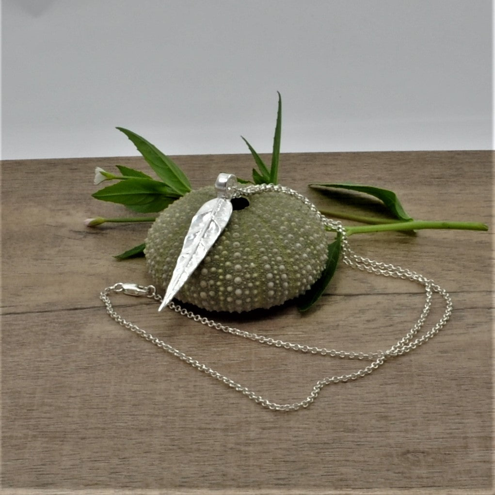 This neckpiece is crafted with 999 fine silver, featuring a textured leaf pattern connected to a P bail, hung on a 925 sterling trace chain and secured with a 925 lobster clasp. This intricate design is perfect for any occasion, and the quality craftsmanship ensures that the piece will last for years. Length of leaf necklace is 260mm (length of chain + leaf) Chain length is 17.5 inches & chain link size is 1.6mm  weighs 5.5g in total (including the chain)