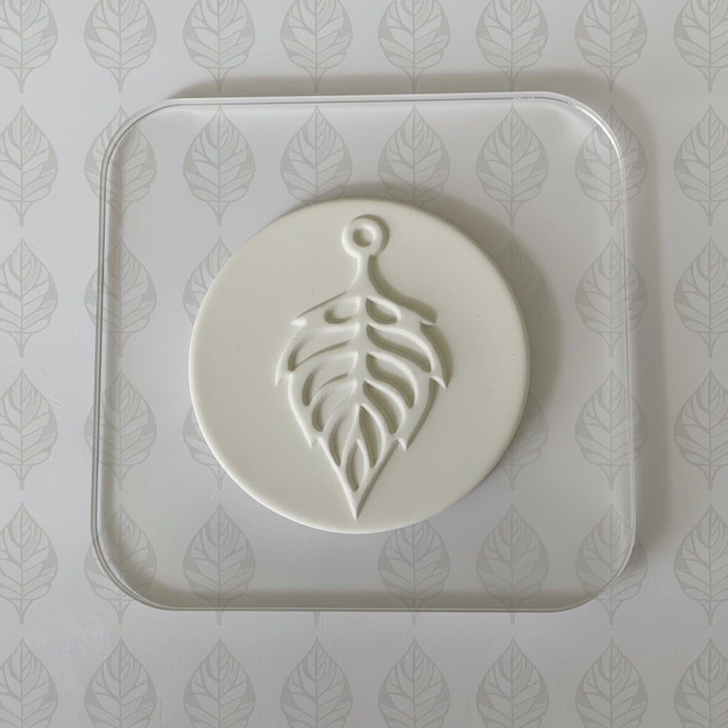 White clay with leaf design on a matching tray against a leaf-patterned background