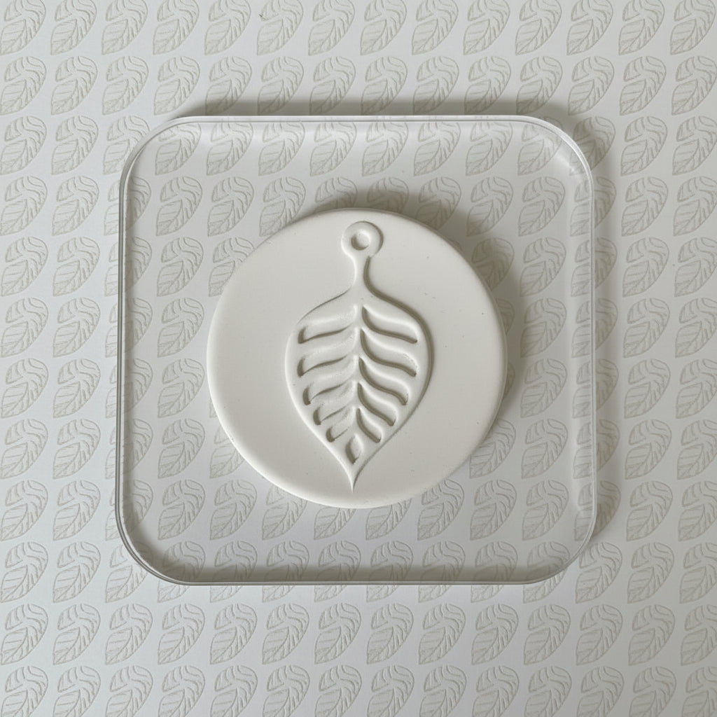 White clay leaf-shaped on a light  background with leaf pattern