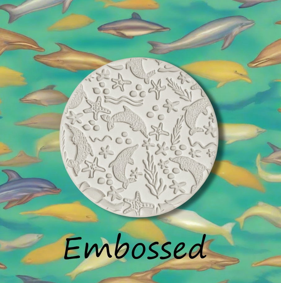 Dolphin sea life debossed in clay Using a  embossed texture mat. This will give you an idea of what it will look like on metal clay or polymer clay
