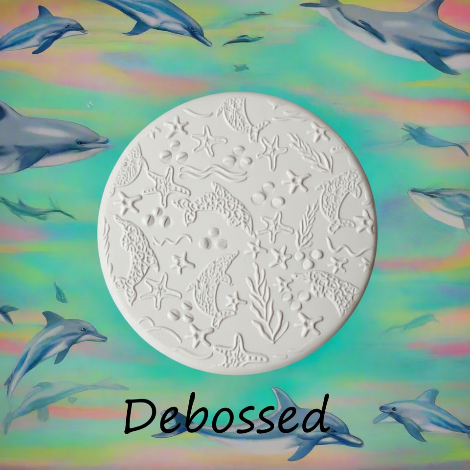 Dolphin sea life embossed in clay Using a  debossed texture mat. This will give you an idea of what it will look like on metal clay or polymer clay