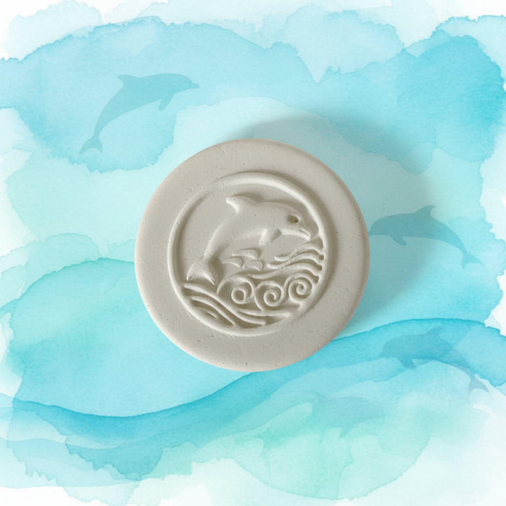 white clay stamped with fish design on a watercolour background
