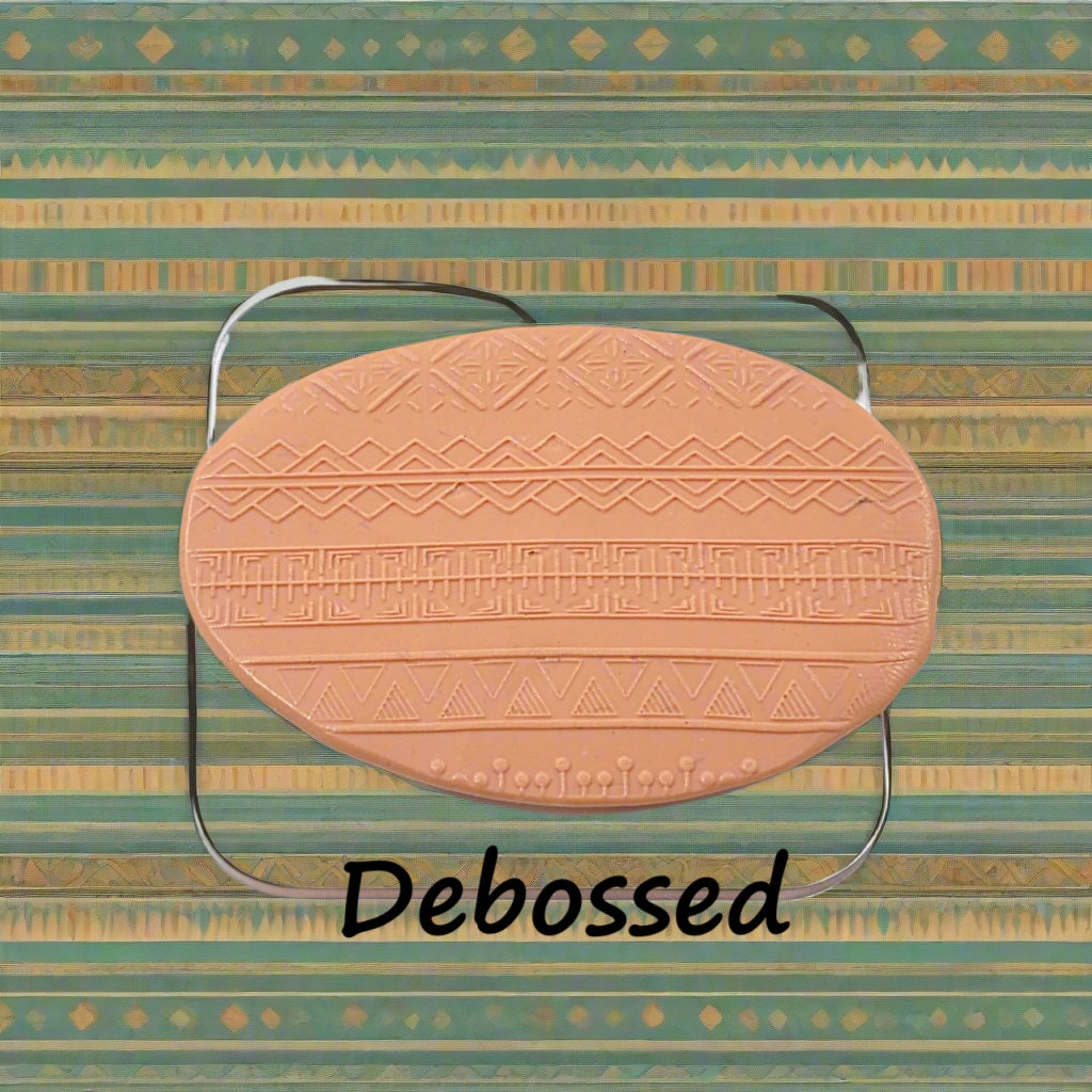 A pattern embossed in silly putty Using an ethnic design debossed texture mat in grey material. This will give you an idea of what it will look like on metal clay or polymer clay.