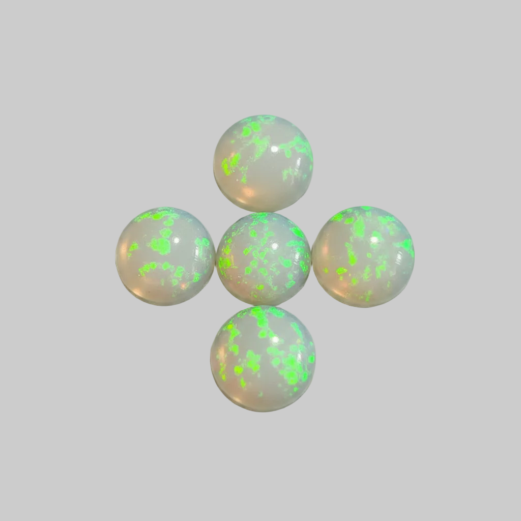 Five round white opal cabochons with vibrant green flashes, arranged on a light gray background.