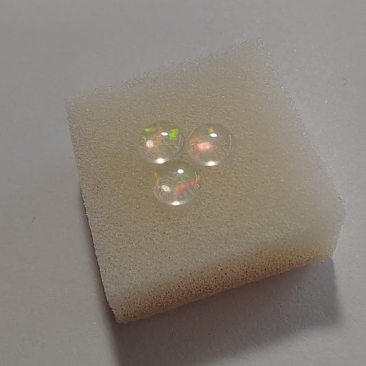 Two opal gemstones on a piece of foam with a light gray background