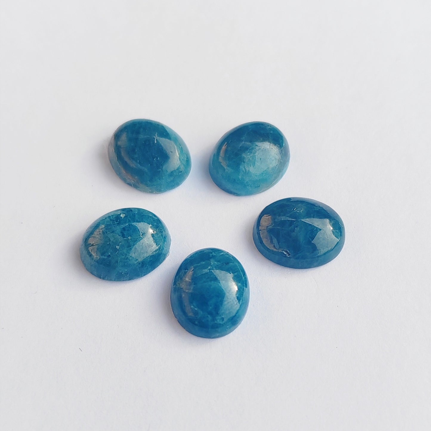 Five blue gemstones on a white background