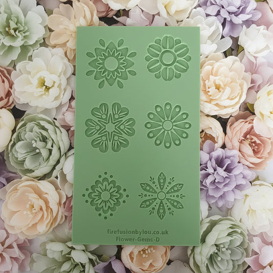 A mint green texture with six embossed floral mandala designs, placed on top of a bed of pastel flowers in white, pink, peach, and lavender.