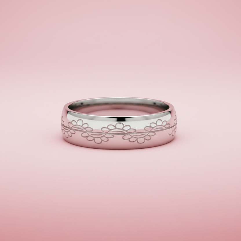 Silver ring with floral engraving on a pink background