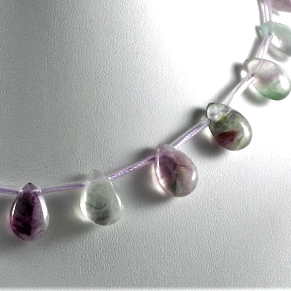 Necklace with teardrop-shaped gemstones on a light gray background