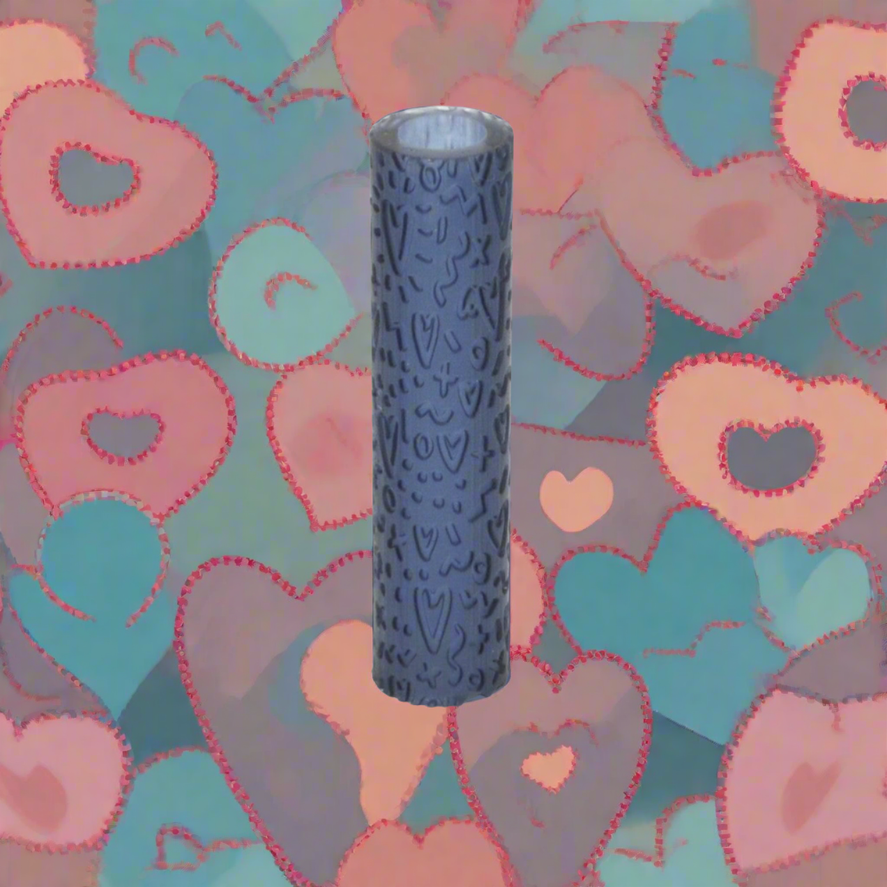 A textured roller for crafting with clay, displayed against a background of decorative hearts.
