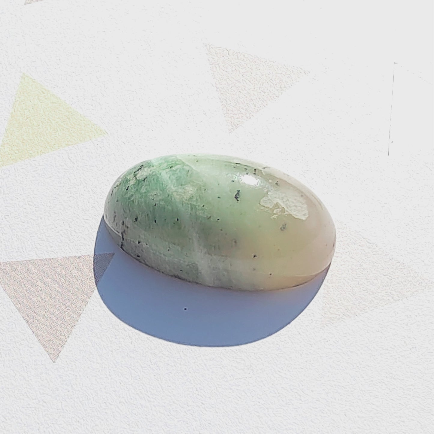 Oval-shaped green stone on a white background