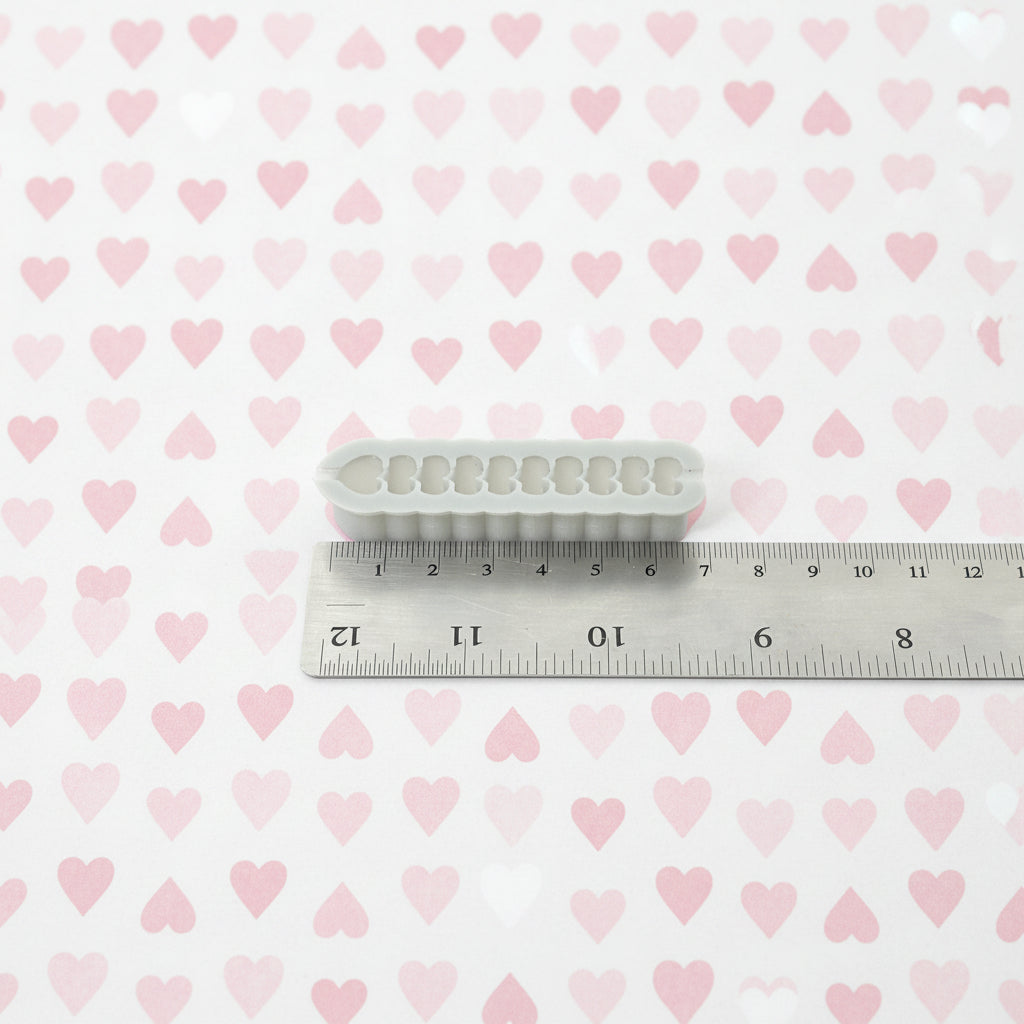 Heart cutter next to a ruler on a white background