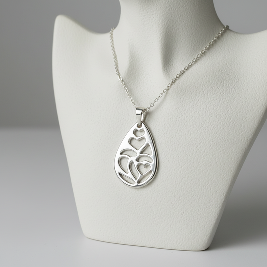 Silver necklace with a heart-shaped pendant on a mannequin bust against a gray background
