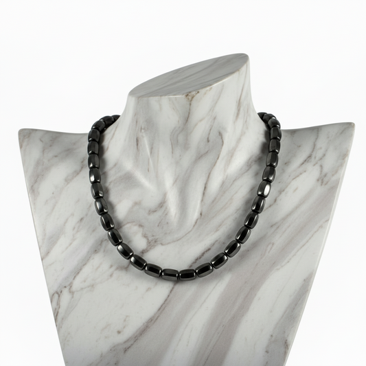 "Hematite barrel beads 9x8mm strand displayed on jewellery bust showing eight sided faceted metallic grey gemstone necklace"