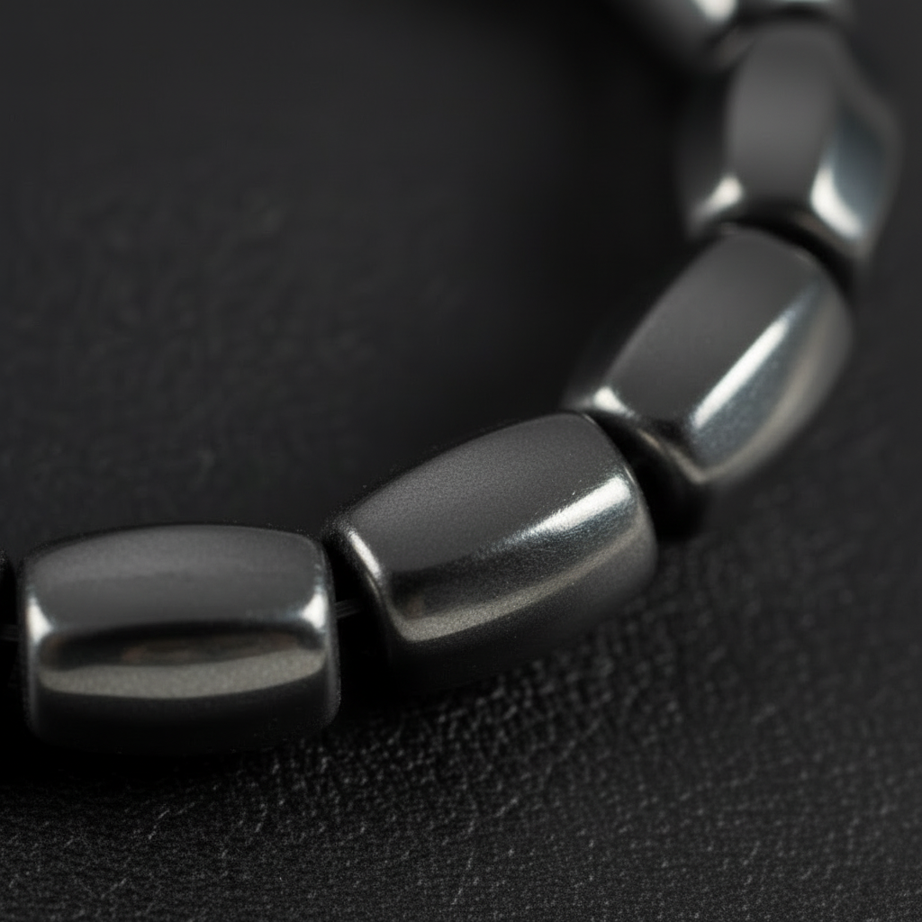 "Close up of eight sided faceted hematite barrel beads 9mm by 8mm showing polished metallic surface and geometric cut"