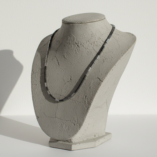 "Hematite cube beads 9x3mm strand displayed on jewellery bust showing slender rectangular metallic grey gemstone necklace"