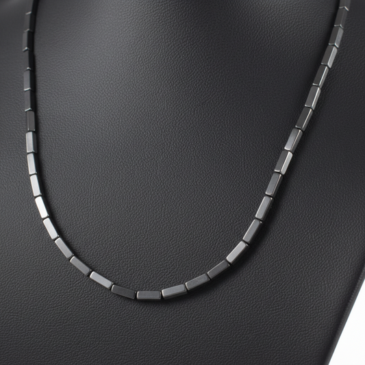 "Close up of hematite cube beads 9mm by 3mm showing slender rectangular geometric shape and polished metallic surface"