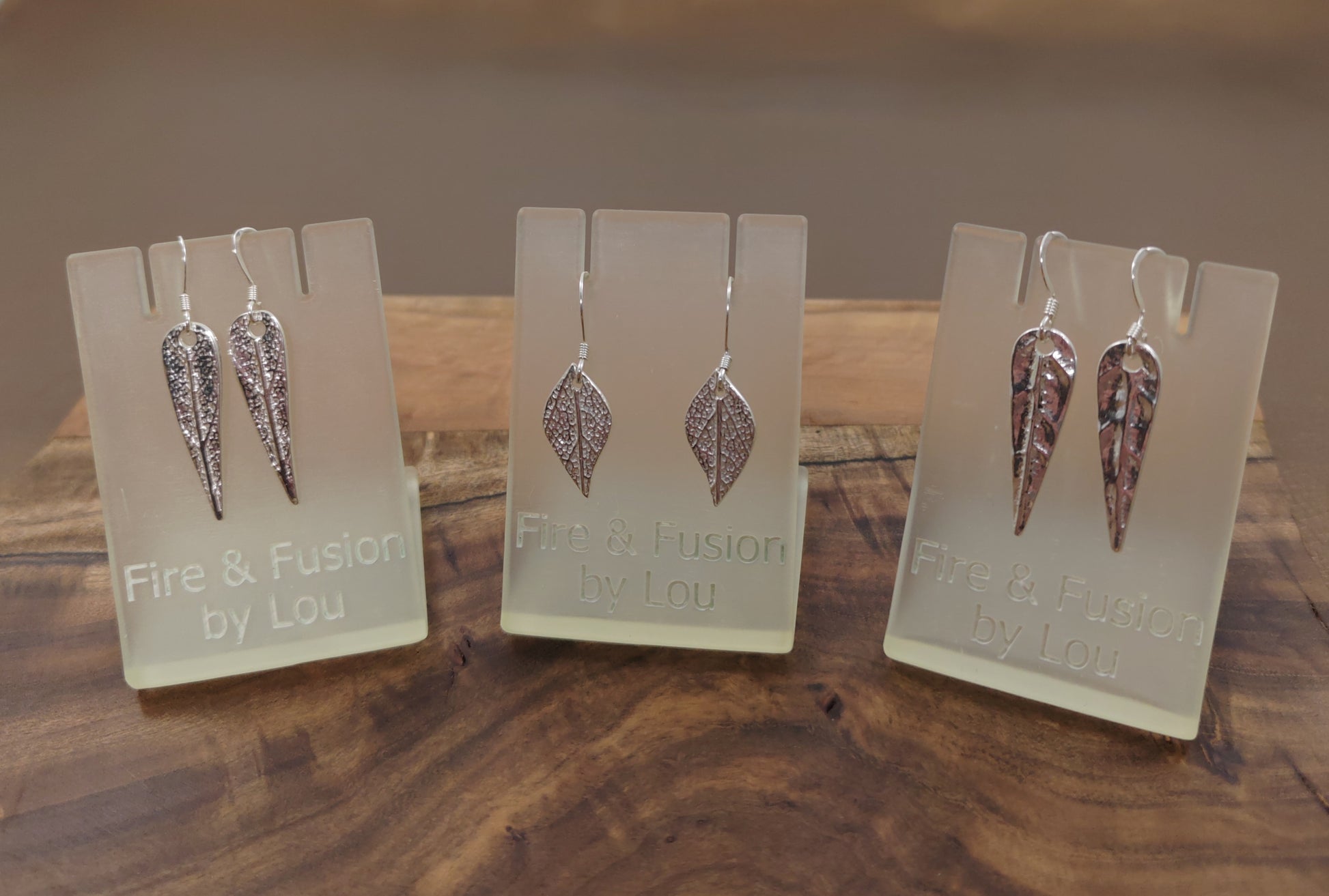 Crafted from 999 fine silver, these earrings each feature a leaf-shaped charm, intricately designed in various patterns and attached to 925 silver French hooks.