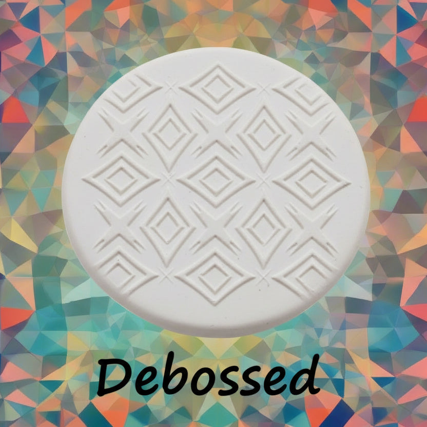 A pattern embossed in clay using a patterned debossed texture mat in grey material. 