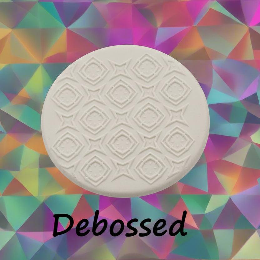 A pattern embossed in clay using a patterned debossed texture mat in grey material. 