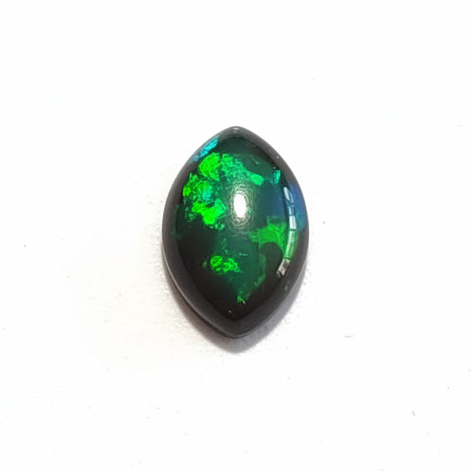 A single polished marquise cabochon gemstone with a dark black base and vibrant green iridescent play-of-color, resting on a neutral light gray textured surface.