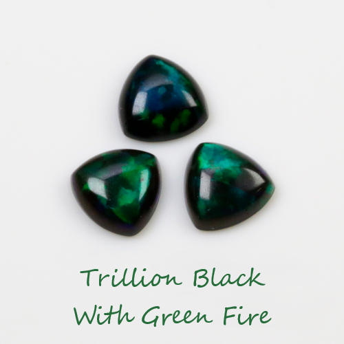 Three trillion cut gemstones with black and green fire on a white background