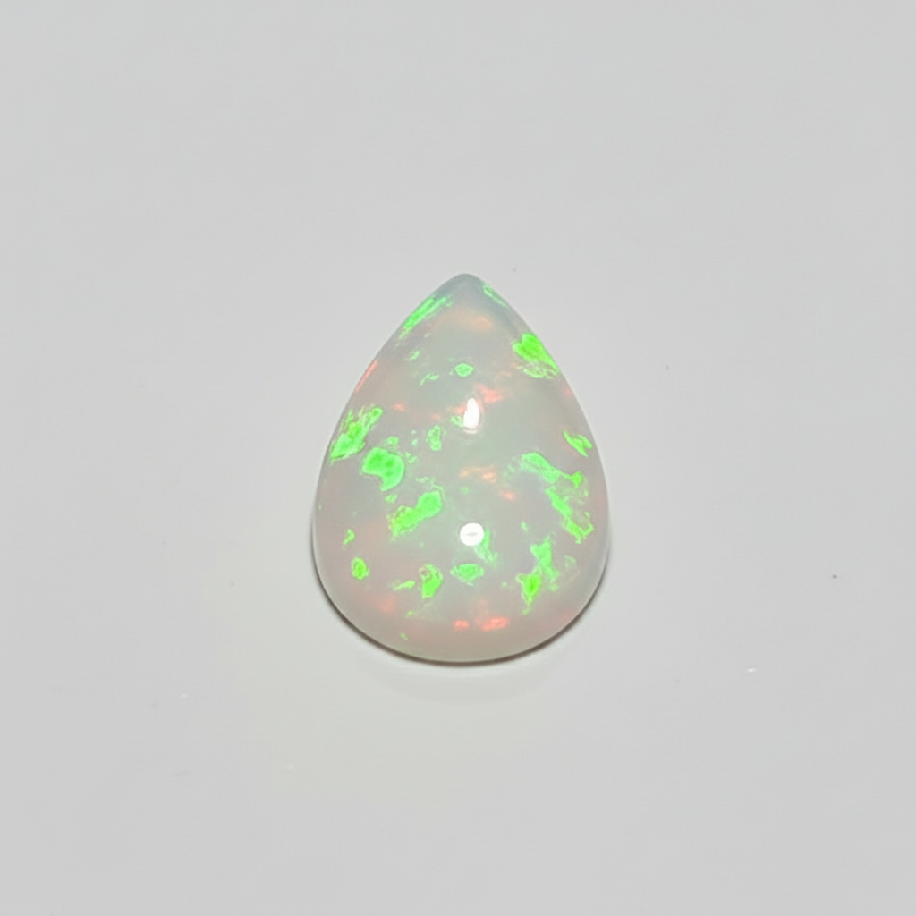 A teardrop-shaped cabochon gemstone with a milky white base and vibrant, shifting internal flashes of neon green and coral pink, set against a plain light grey background.