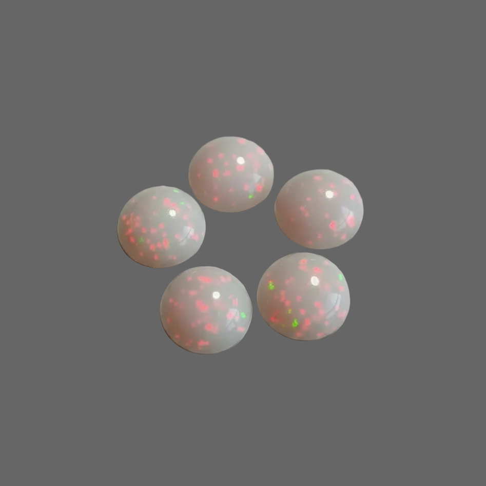 Five round cabochon gemstones with a milky white base and vibrant pink, orange, and green flashes, arranged in a circle on a light gray background.