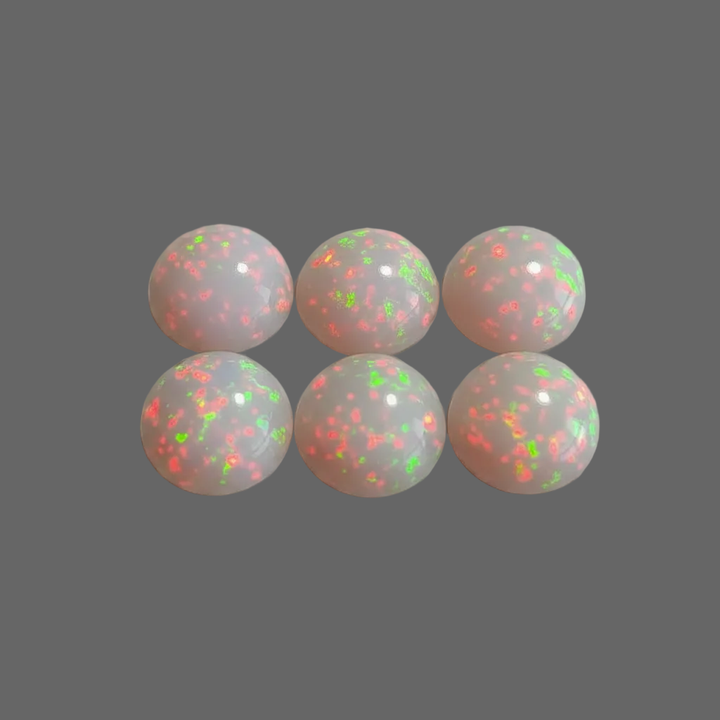 Six round cabochon gemstones with a milky white base and vibrant neon orange and green opal fire, arranged in two rows of three on a neutral gray background.