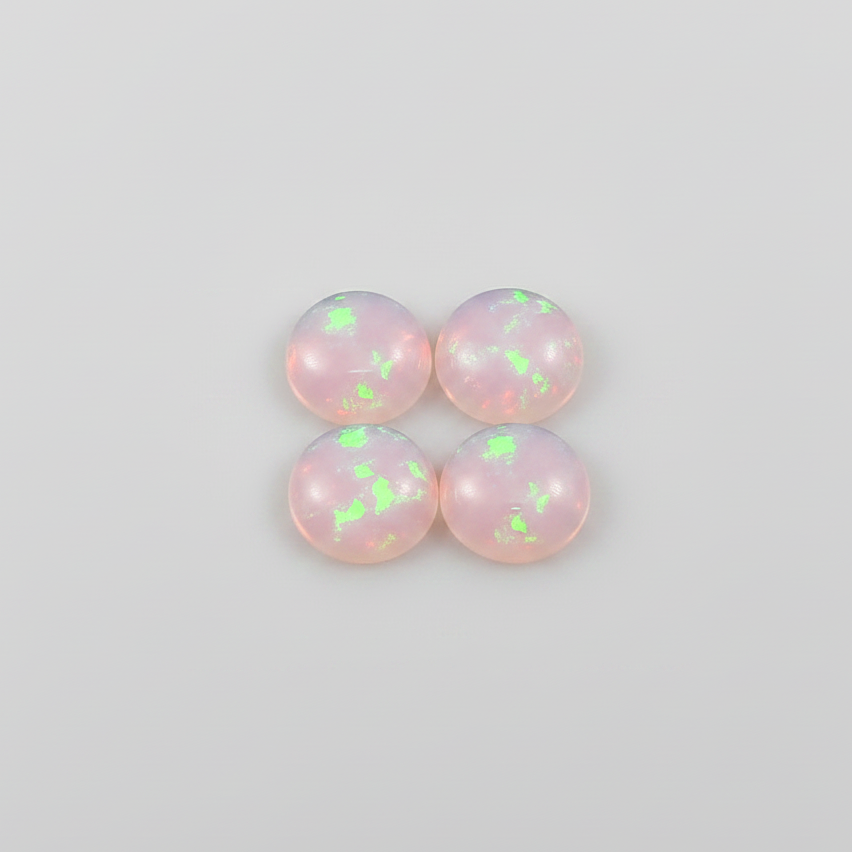 Four round cabochon opal gemstones arranged in a 2x2 grid on a light gray background. The opals exhibit a milky white base with vibrant flashes of neon green and soft pink.