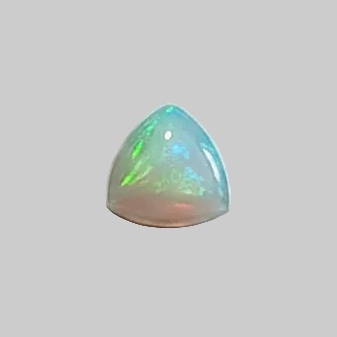 A triangular cabochon gemstone with a vibrant play-of-colour display of green, blue, and pink, set against a solid grey background.