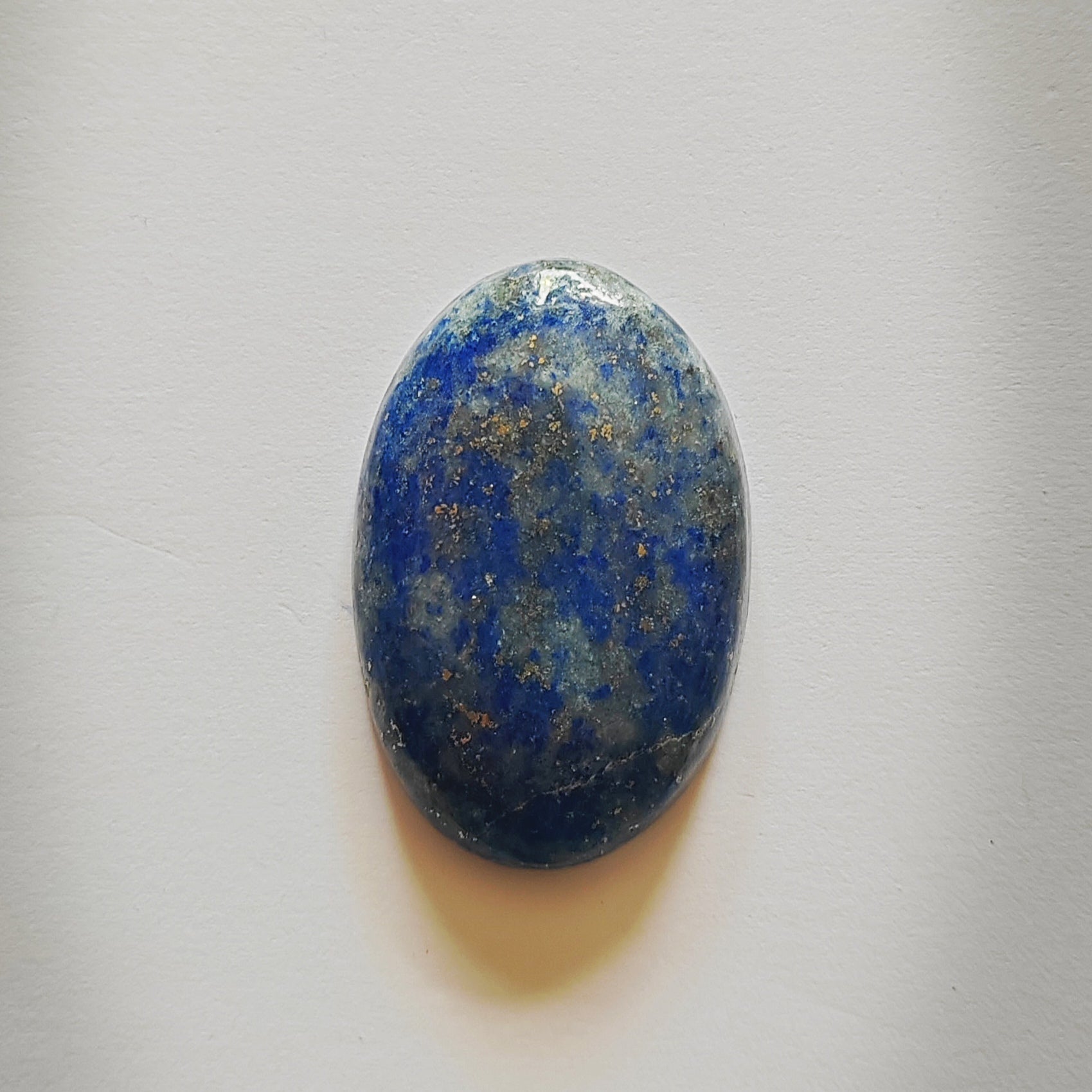 Oval-shaped blue stone on a light gray background