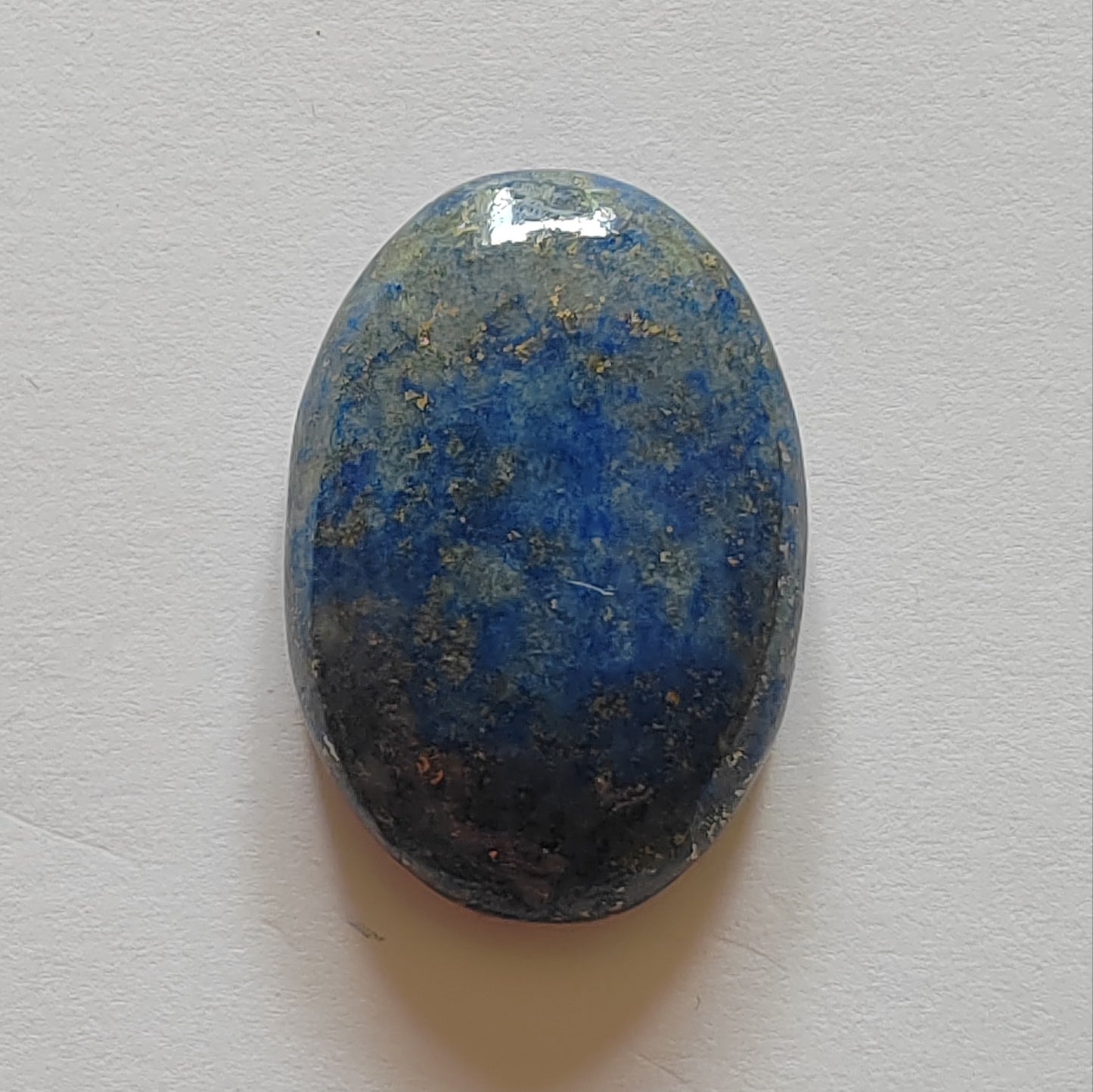Oval-shaped blue stone on a light grey background