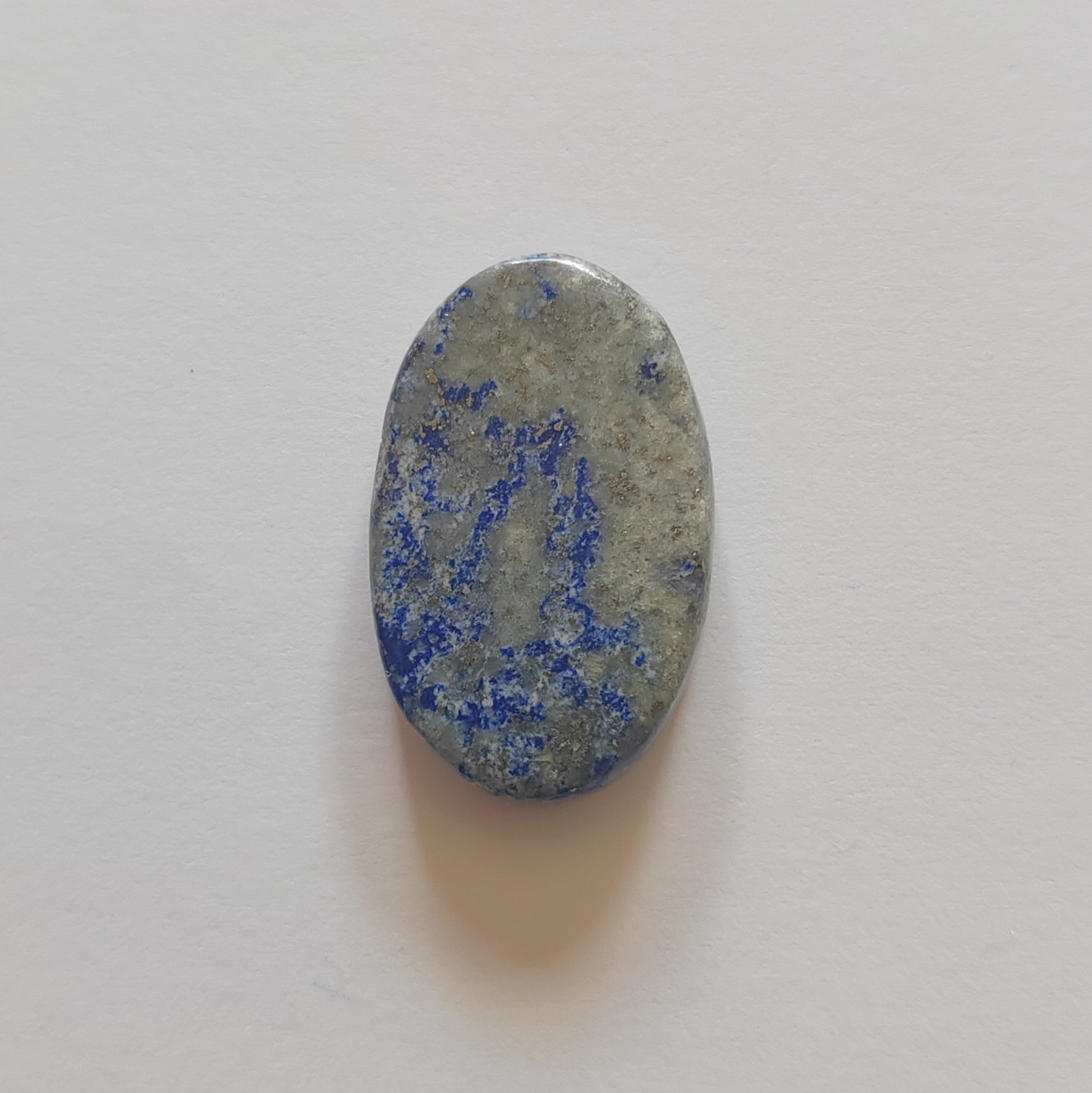 Oval-shaped stone with blue and gray patterns on a light gray background