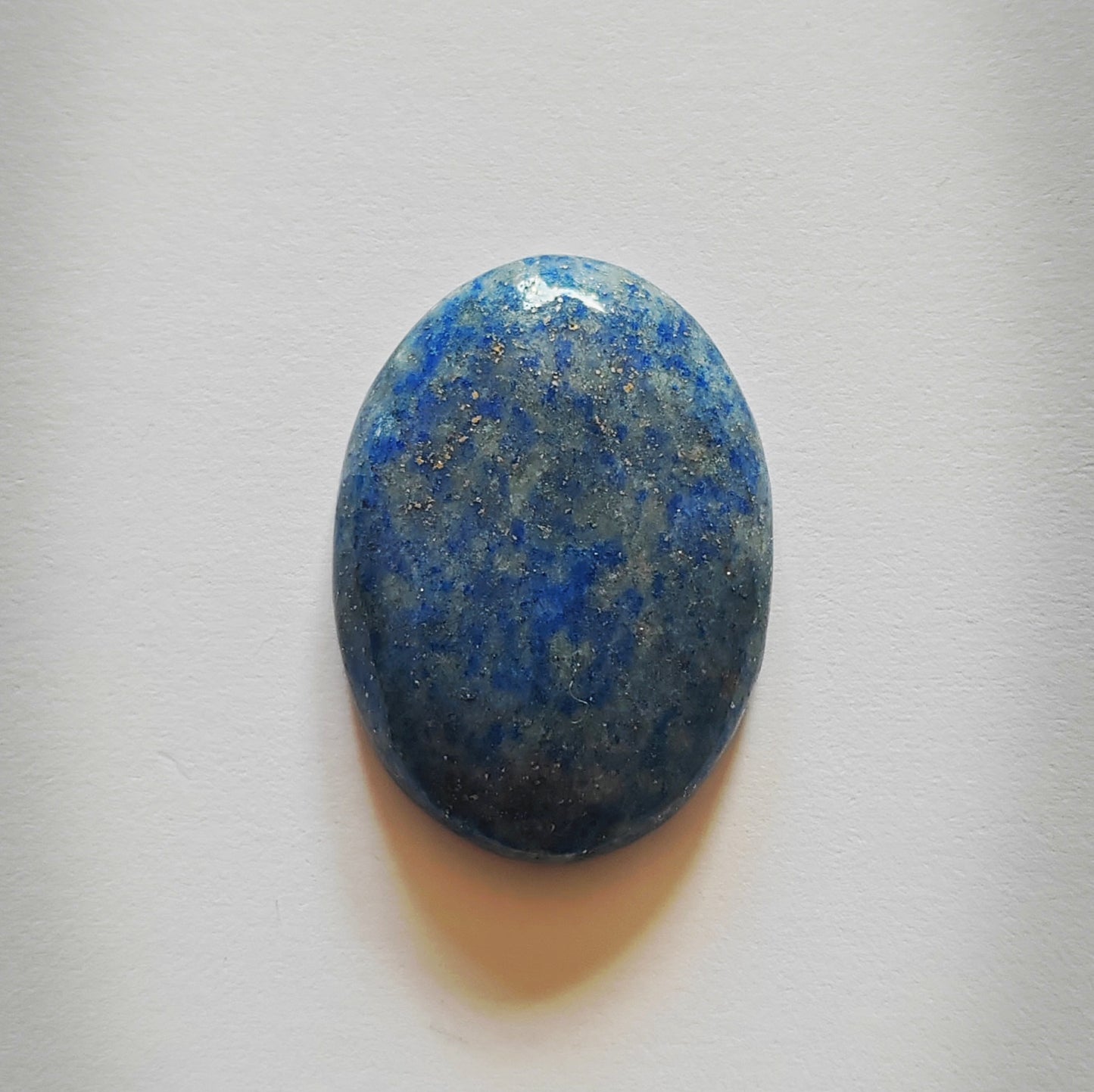 Oval-shaped blue stone on a white background