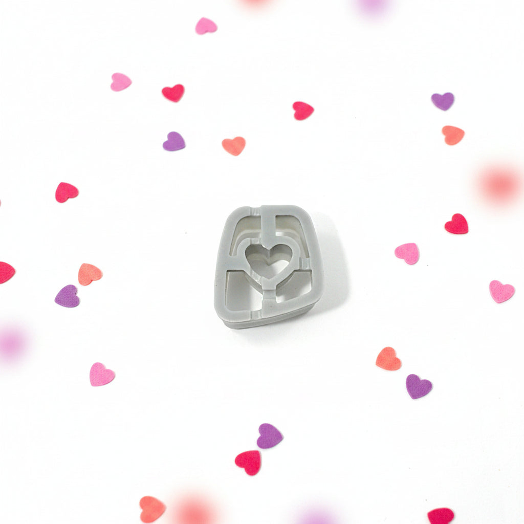 Heart-shaped  cutter on a white background with colourful heart-shaped confetti