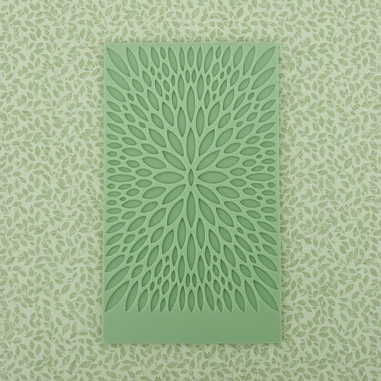 A rectangular mat with a radial, leaf-like cut out pattern.