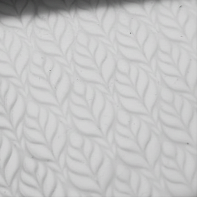 Close-up of textured white clay with a subtle leaf pattern