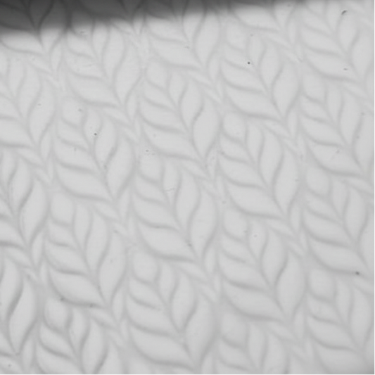 Close-up of textured white clay with a subtle leaf pattern