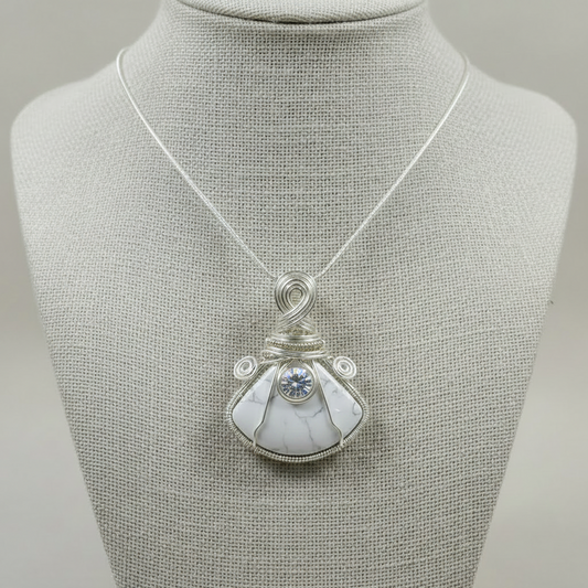Necklace with a white stone pendant on a mannequin bust against a gray background