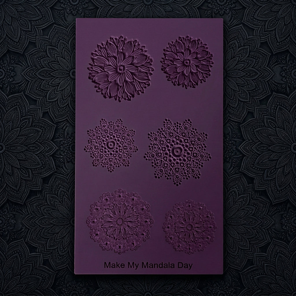 A dark pink rectangular texture with six embossed mandala and floral patterns, featuring the brand name 'Make My Mandala Day' at the bottom, set against a plain dark grey background.