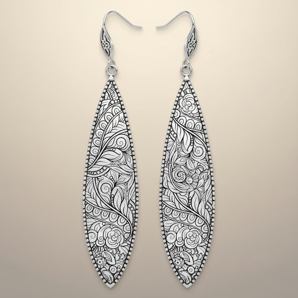 Pair of silver earrings with intricate black floral patterns on a white background